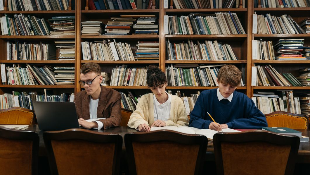 Tre ragazzi che studiano in aula studio