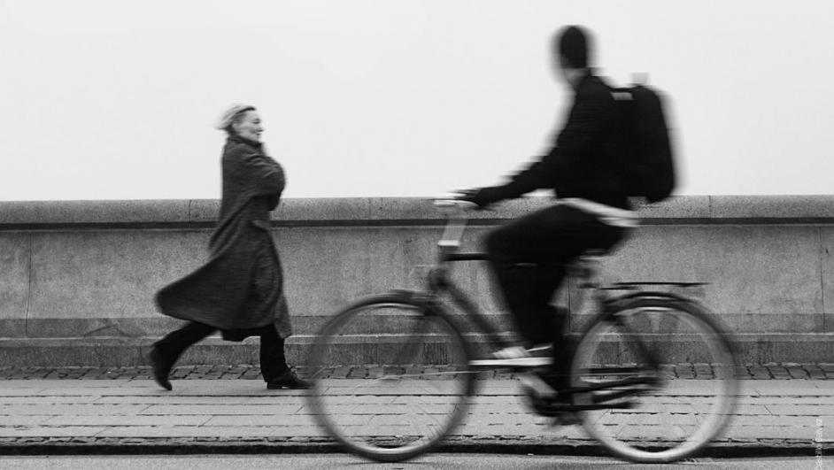uomo in bicicletta e donna che cammina sul marciapiede