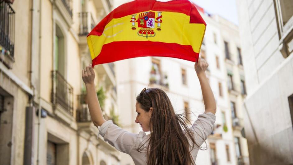 ragazza che sventola la bandiera spagnola