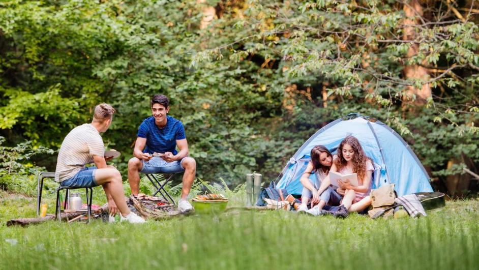 gruppo di ragazze e ragazzi in un campo estivo con tenda