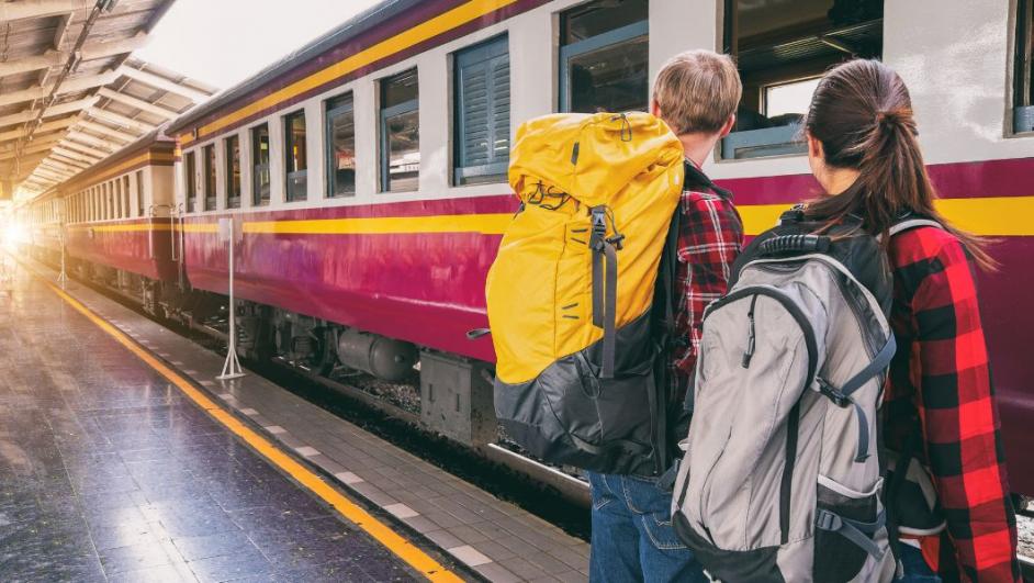 due ragazzi con zaino in spalla viaggiano in treno